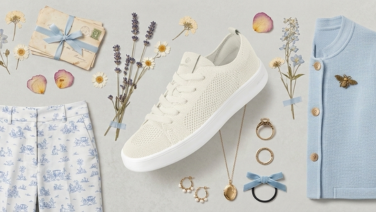 Flat lay of a feminine spring outfit in cream and light blue: patterned trousers, light blue cardigan, cream-coloured Giesswein Merino sneakers and accessories such as a necklace and hairband decorated with dried flowers.