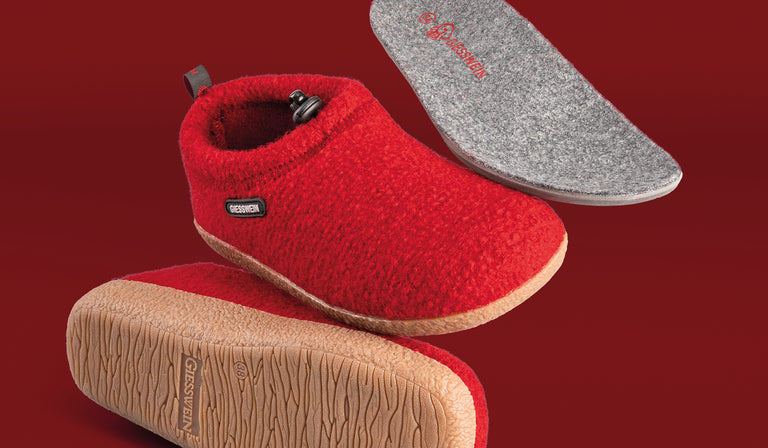 Red Giesswein wool slippers shown from multiple angles including sole, insole, and side views against a red background, displaying the textured outsole and gray branded insole.