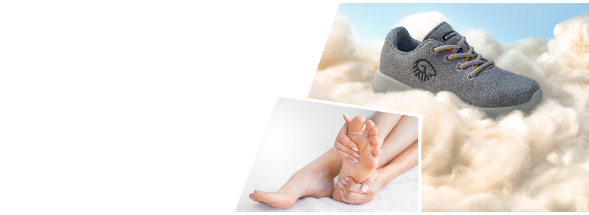 A soft grey orthopedic shoe with beige laces rests on fluffy white wool, suggesting extreme comfort. The shoe features a black embroidered logo and a label that reads “GIESSWEIN.” In the bottom left, there's an inset image of a person gently massaging their bare foot, emphasizing foot care and relief. The background is light and airy, enhancing the feeling of softness and comfort.