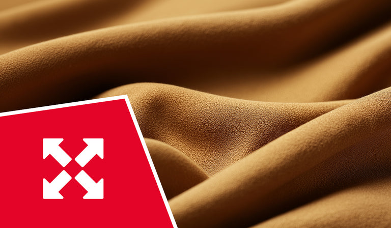 Flowing golden-brown fabric with soft curves and texture. A red icon displays four white arrows pointing outward in all directions, indicating stretch or flexibility properties.