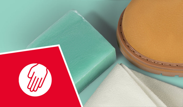 Green soap bar, beige shoe sole, and white towel arranged together. A red icon shows a white hand symbol, indicating hand-washable or care properties.