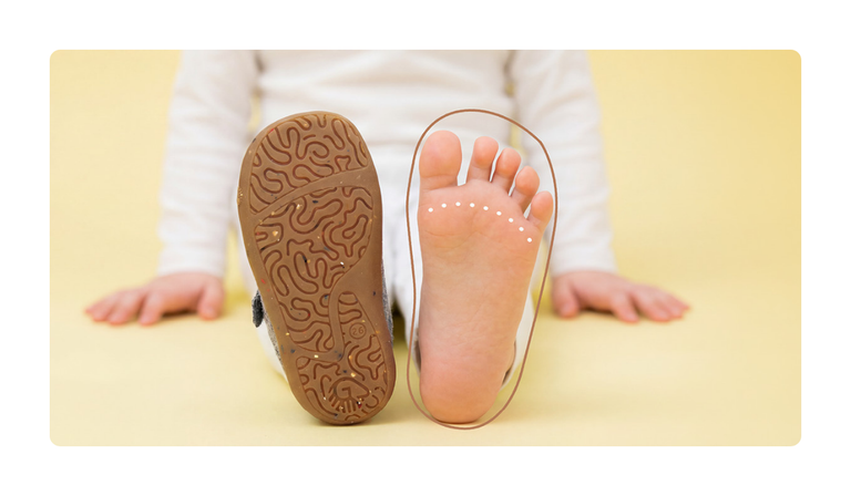 A child stretches out both feet – on the left, the sole of a Giesswein children’s shoe with a textured natural rubber tread; on the right, the bare foot with a graphic outline to illustrate the foot-friendly fit.
